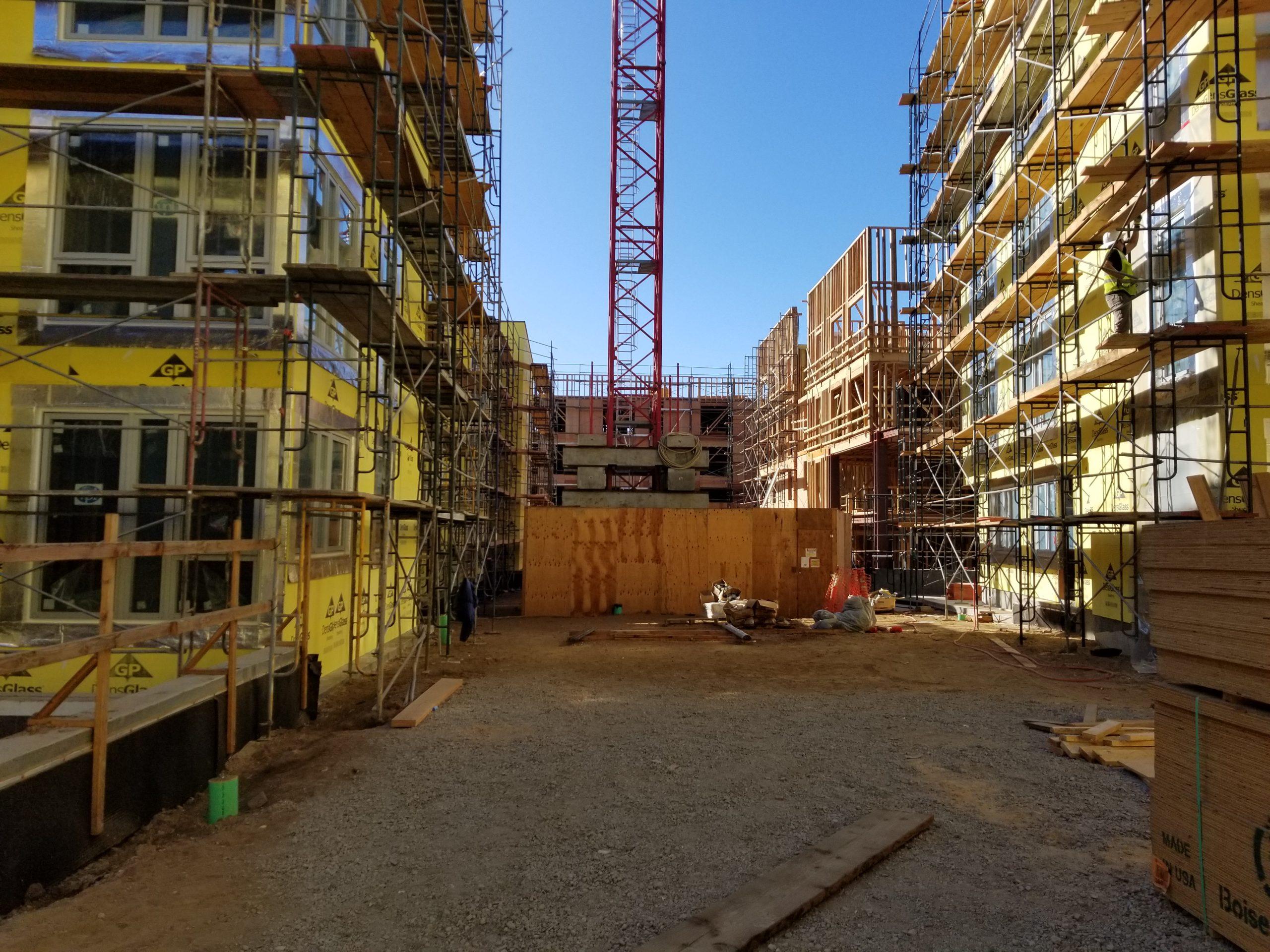 Multi-building construction site with framing and scaffolding in progress