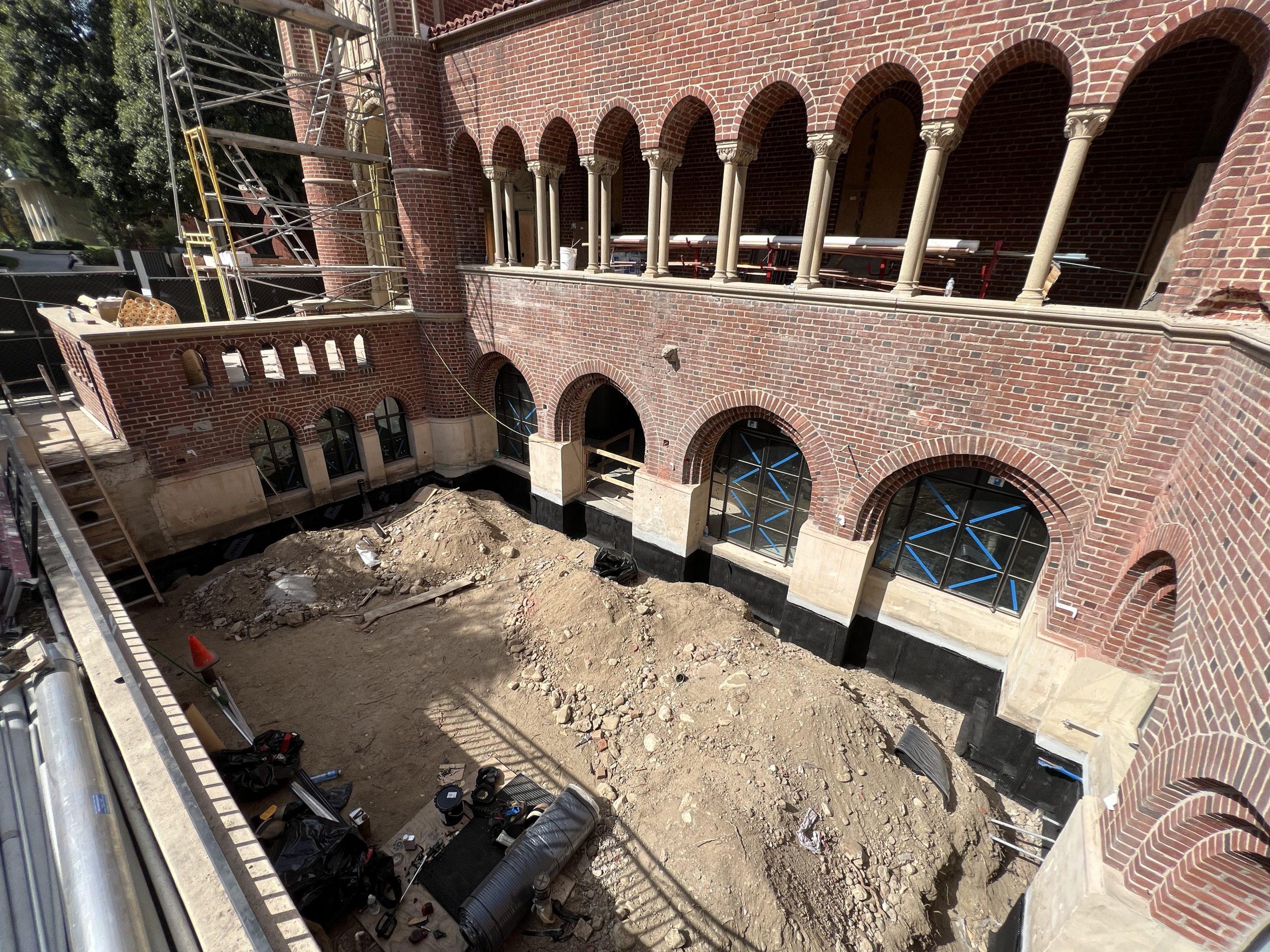 Excavation and structural work within a historic brick courtyard
