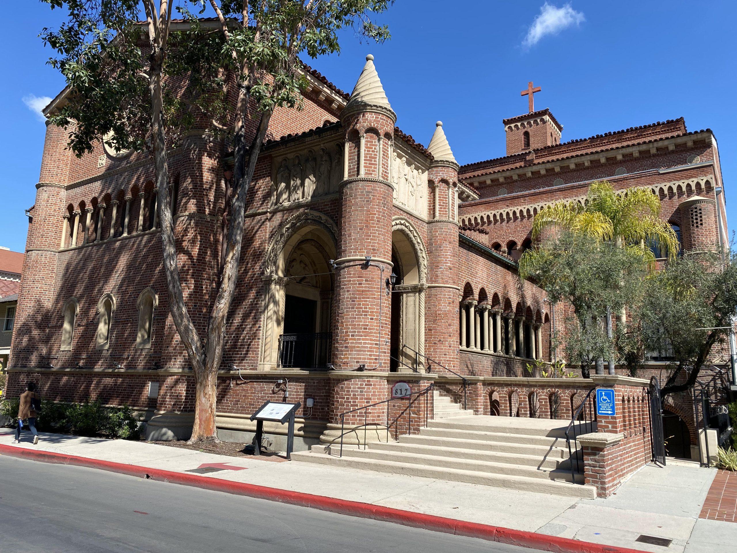Historic brick community building with a tower and arched windows