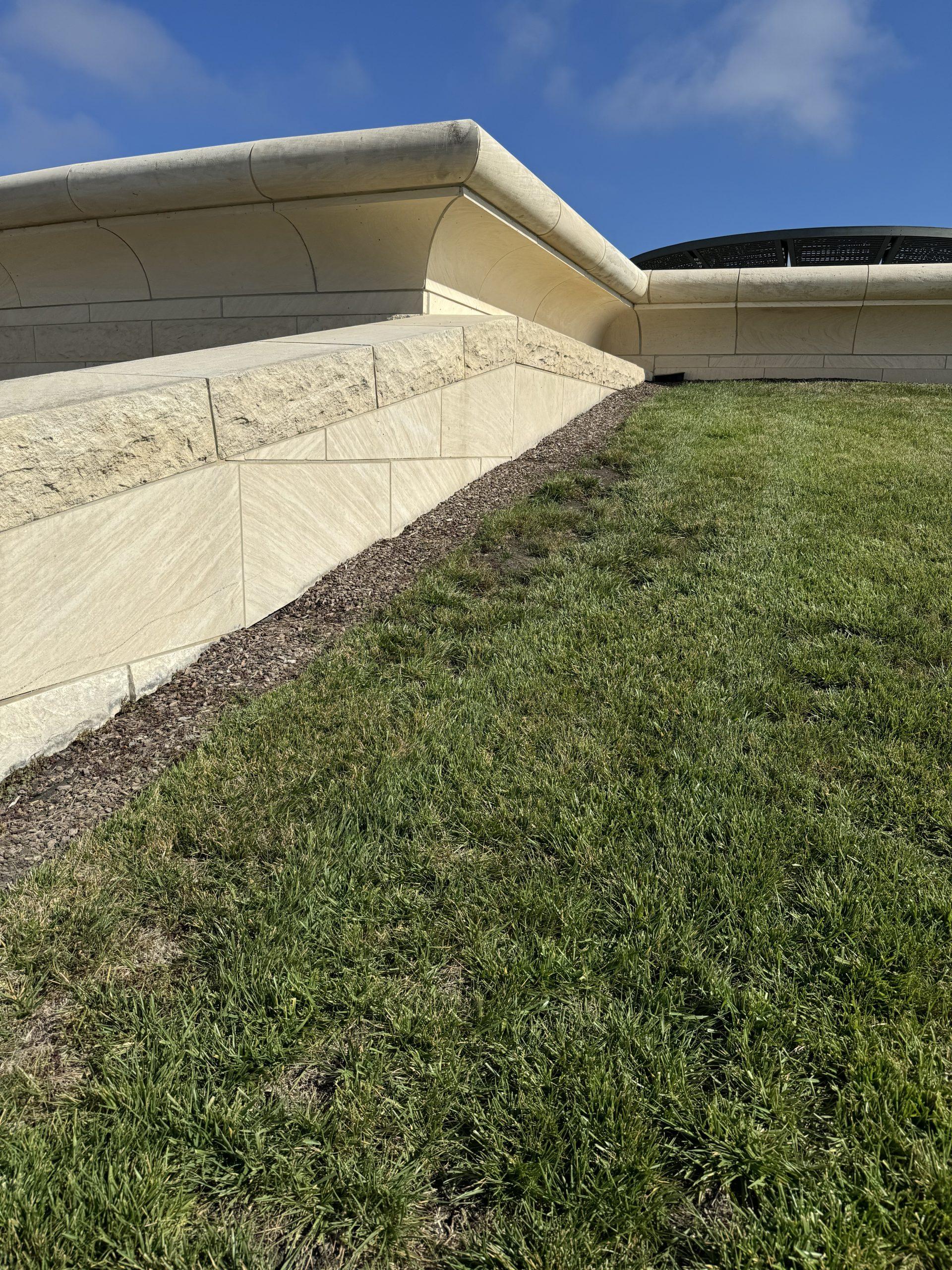 Stone roofline and planted terrace at a cultural building